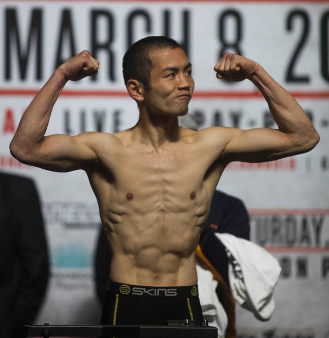 Lightweight Nihito Arakawa of Japan flexes for the crowd while on the scale during his weigh-in at the MGM Grand Arena on Friday, March 07, 2014.